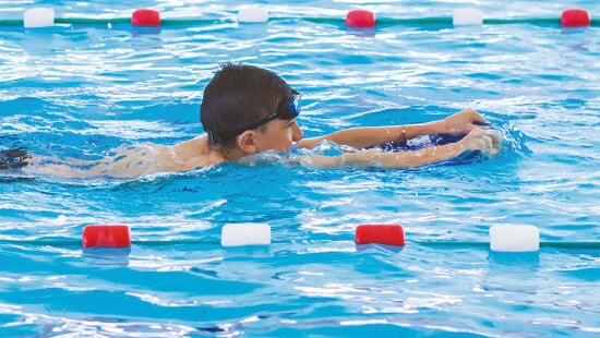 Enfant nageant avec une planche
